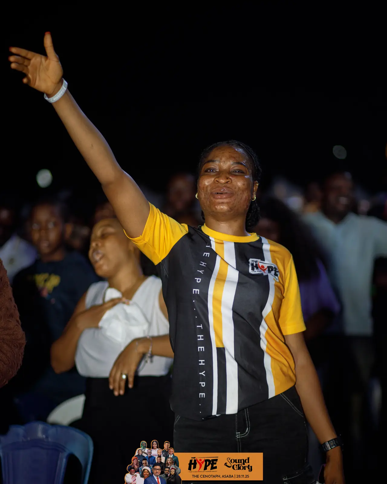 A worshipper with her hand raised high in the crowd