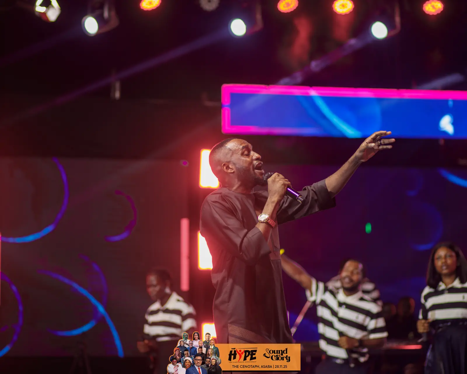 A minister singing with the praise team behind him
