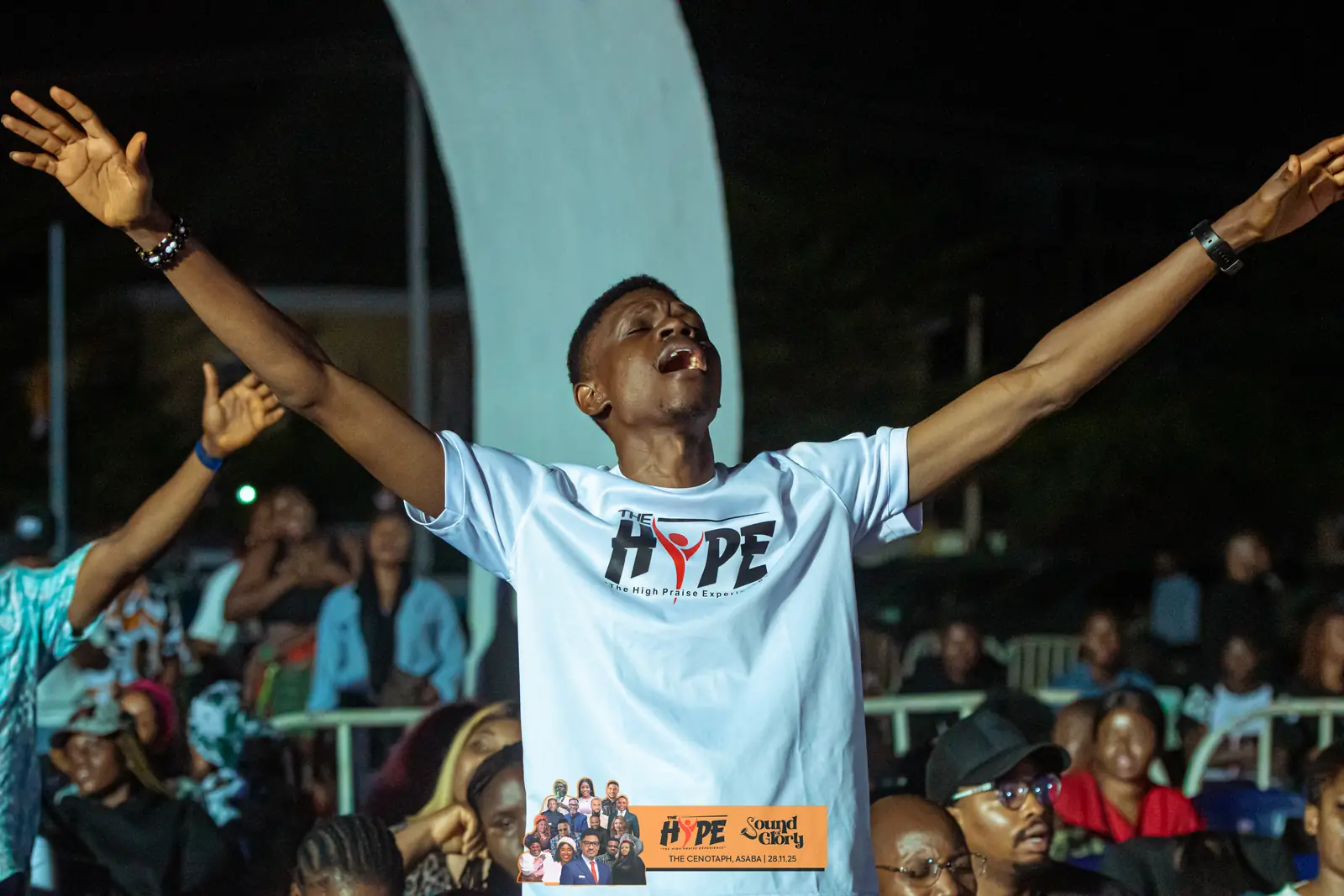 A worshipper with his arms stretched wide in a HYPE shirt